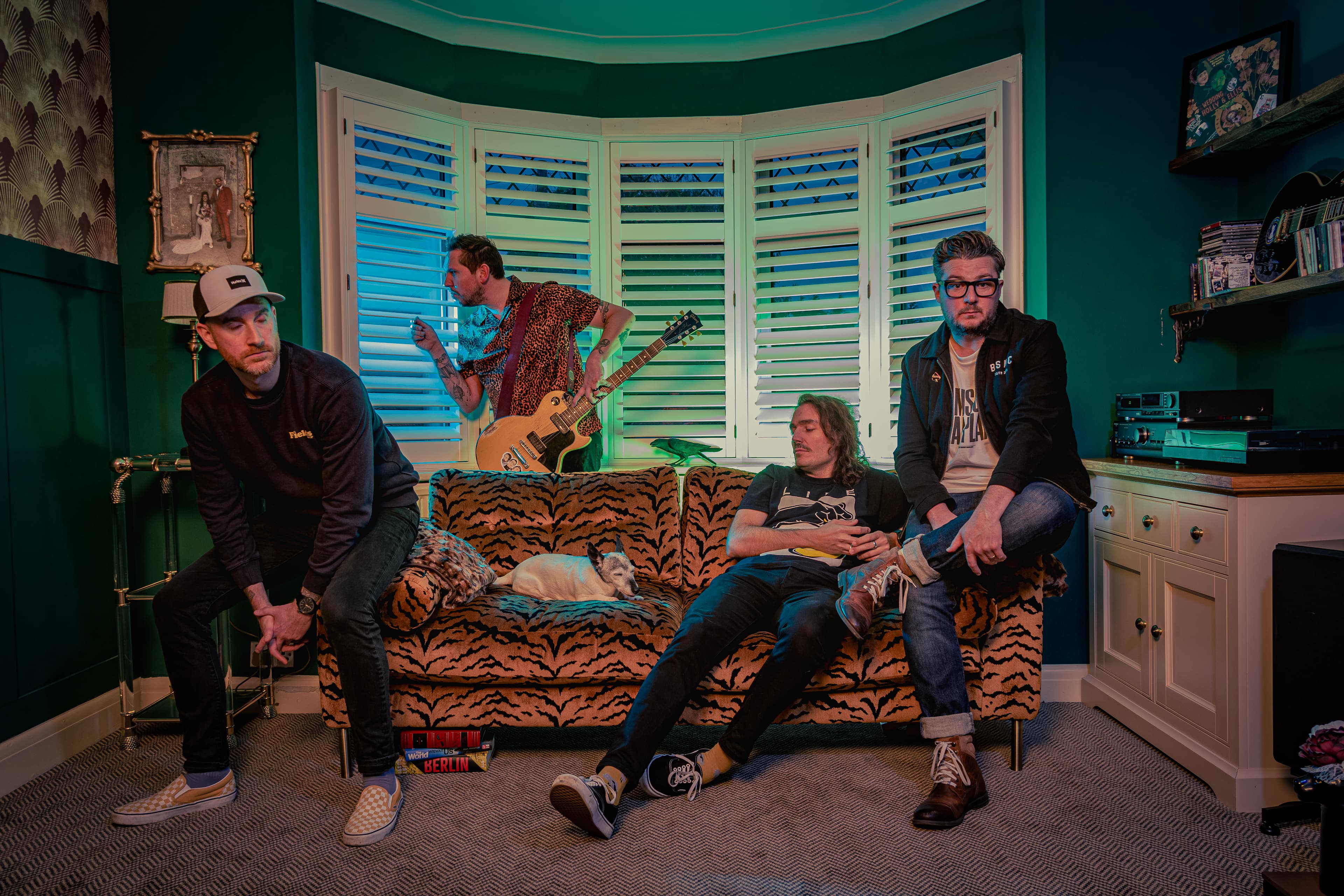 Ellis Slater & The Night Shift in a green room with guitars and a tiger-print sofa